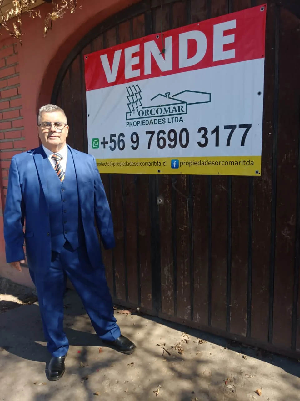 Don Mario Rivas Hernández junto a un letrero de venta de ORCOMAR